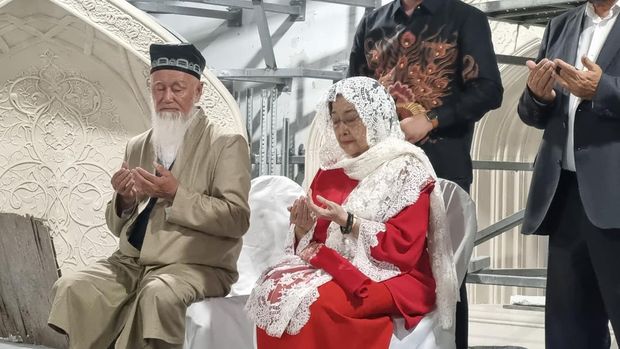 Ketum PDIP Megawati Soekarnoputri memakai kerudung putih milik ibundanya, Fatmawati, saat berziarah ke Makam Imam Al Bukhari di Samarkand, Uzbekistan