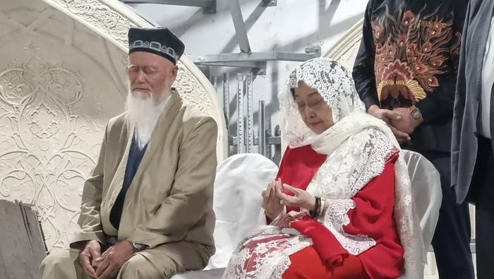 Ketum PDIP Megawati Soekarnoputri memakai kerudung putih milik ibundanya, Fatmawati, saat berziarah ke Makam Imam Al Bukhari di Samarkand, Uzbekistan