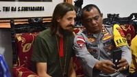 Dalam foto yang dirilis Satgas Damai Cartenz Sabtu (21/9/2024), Kapten Philip telah didampingi anggota Polri. Kapten Philip memakai kaus berwarna hijau tua, di lehernya ada kain seperti dasi berwarna merah dan memiliki gambar berwarna hitam. Dia juga memakai kalung dan gelang yang terlihat terbuat dari kayu. Kapten Philip juga mengenakan celana pendek dan kaus kaki setinggi betis dan sepatu. (Satgas Damai Cartenz via AP)