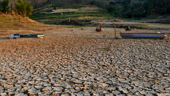 Warga berjalan di dasar Waduk Bendo yang mengering di Kabupaten Ponorogo, Jawa Timur, Jumat (20/9/2024). Sejak sebulan terakhir, waduk yang memiliki kapasitas volume sekitar 43 juta meter kubik air itu mengering akibat musim kemarau. ANTARA FOTO/Siswowidodo/agr *** Local Caption ***