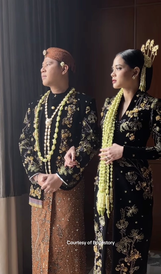 Nino dan istrinya yang akrab disapa Ica itu memilih menggunakan busana adat Jawa dalam upacara resepsi pernikahan mereka. Nino tampak gagah mengenakan beskap beludru hitam, lengkap dengan kain batik. Foto: dok. The Bride Story