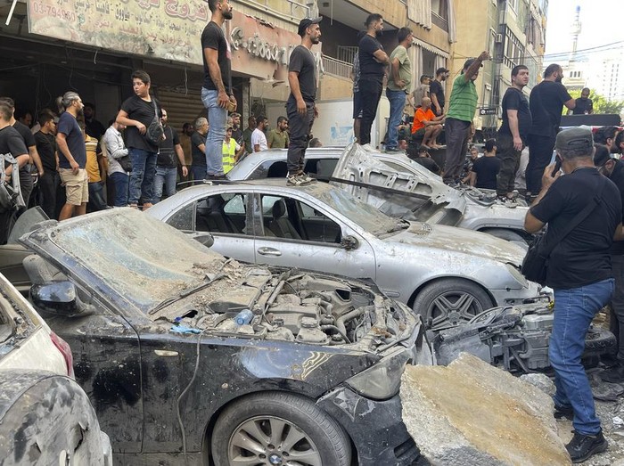 People gather at the scene of an Israeli missile strike in the southern suburbs of Beirut, Friday, Sept. 20, 2024. (AP Photo/Bilal Hussein)