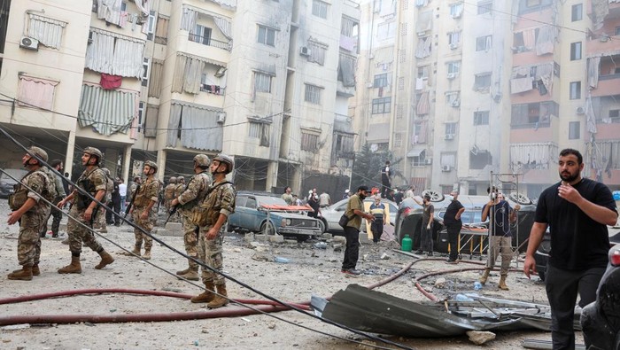 People and members of the military inspect the site of an Israeli strike in the southern suburbs of Beirut, Lebanon, September 20, 2024. REUTERS/Mohamed Azakir     TPX IMAGES OF THE DAY