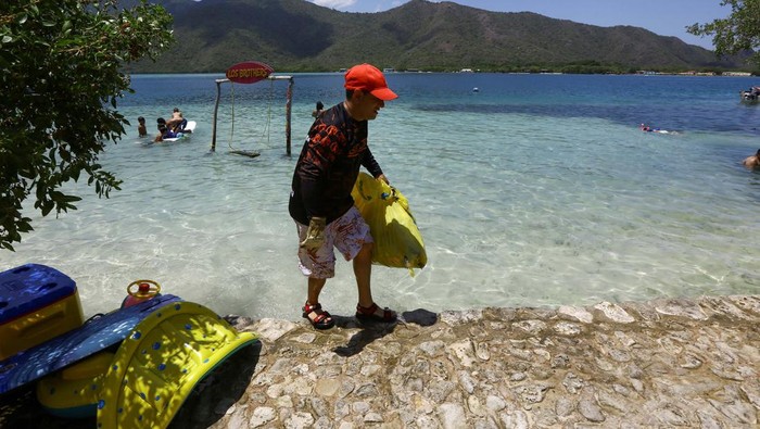A volunteer collects trash during the cleanup operation as part of World Beach Day activities, in La Cienega, Venezuela, September 21, 2024. REUTERS/Juan Carlos Hernandez