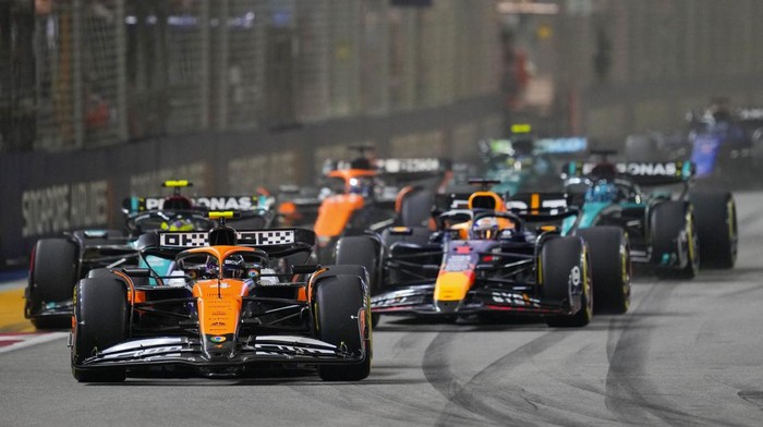 McLaren driver Lando Norris, left, of Britain leads Red Bull driver Max Verstappen of the Netherlands into turn one at the start of the Singapore Formula One Grand Prix at the Marina Bay Street Circuit, in Singapore, Sunday, Sept. 22, 2024. (AP Photo/Vincent Thian)