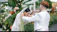 Hana Saraswati mengumumkan pernikahannya di akun Instagram pribadinya. Hana dan suami memakai baju pengantin bernuansa putih dengan kain batik berearna coklat dengan motif senada. Foto: dok. @thepotomoto