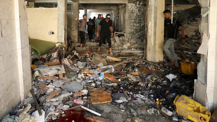 Israel Serang Sekolah di Gaza, 21 Orang Tewas Palestinians inspect a school, which was sheltering displaced people, after it was hit by an Israeli strike, amid the Israel-Hamas conflict, in Gaza City, September 21, 2024. REUTERS/Dawoud Abu Alkas