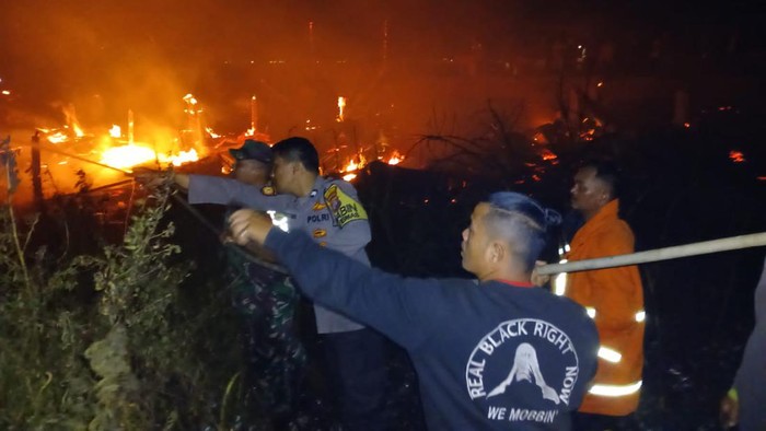 Petugas saat memadamkan api yang membakar gubuk. Foto: (Dok. Polsek Parapat)