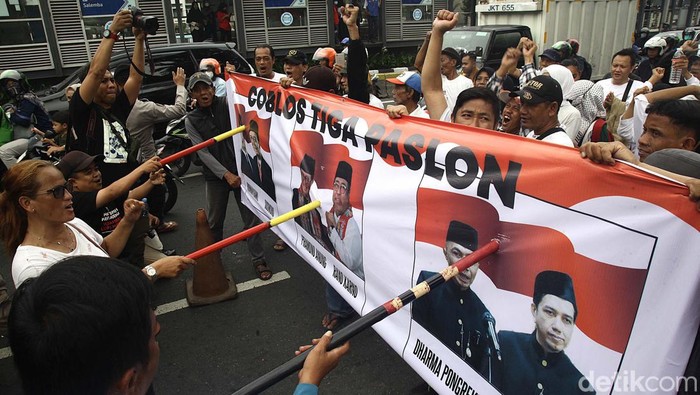 Aksi Coblos Tiga Paslon di Pilkada Jakarta Massa dari Jaringan Rakyat Miskin Kota (JRMK) Jakarta berunjuk rasa di depan kantor KPU Provinsi Jakarta, Jl Salemba Raya, Senin (23/09/2024). Unjuk rasa tersebut diwarnai aksi mencoblos 3 pasang cagub-cawagub Jakarta. Selain itu, JRMK menyatakan sikap memilih golput dalam Pilgub Jakarta karena ketiga paslon dinilai jadi alat bagi para elit untuk melanggengkan kekuasaan dan tidak memihak rakyat.