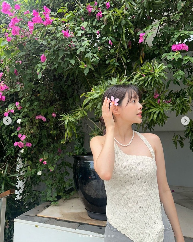 Tak hanya berpose menyelipkan bunga di telinga. Chuu bahkan telah mengganti foto akun Instagram-nya dengan fotonya berdiri di dekat bunga kamboja di Bali. Foto: dok. Instagram @chuuo3o