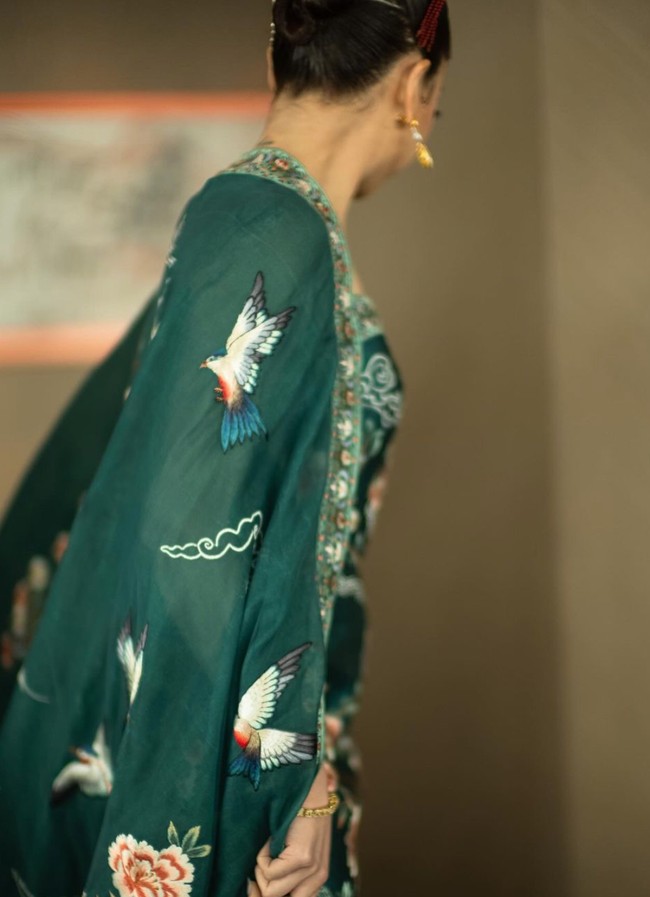 Sementara Clarissa tampil cantik mengenakan cheongsam rancangan desainer Hian Tjen. Senada dengan suaminya, cheongsam yang dikenakan Clarissa juga berwarna hijau emerald dengan motif burung dan bunga. Foto: Instagram/@clarissatanoe