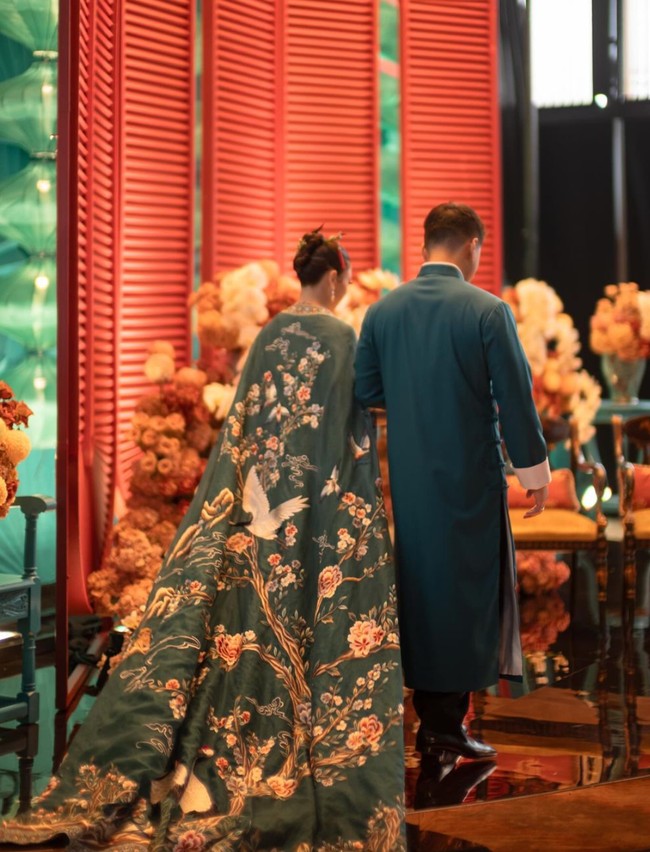 Terlihat dari belakang jubah cheongsam Clarissa tampak begitu cantik dengan gambar pohon berbunga dan burung-burung merpati. Tampak juga keduanya yang begitu serasi kala berdiri berdampingan. Foto: Instagram/@clarissatanoe