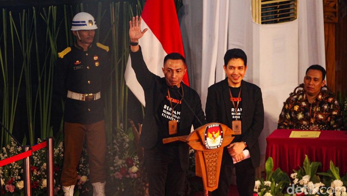 Pasangan cagub-cawagub Jakarta Dharma Porengkun-Kun Wardana mendapat nomor urut 2 di Pilkada. Dharma berpose salam Pancasila saat berpidato.