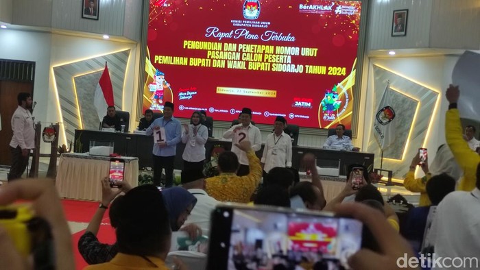 Dua paslon Pilbup Sidoarjo 2024 menunjukkan nomor urut hasil pengundian di Kantor KPU.