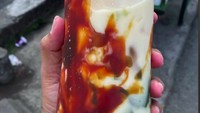 Es Cincau Pak Yanto di Surakarta disajikan dalam plastik panjang dan penuh. Paduan cincau yang kenyal ditambah dengan santan dan gula ini dibanderol Rp 5.000. Foto: TikTok @infomakansolo