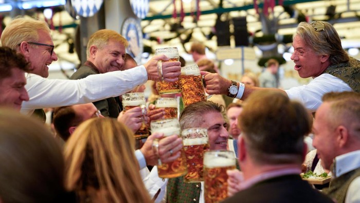 Visitors cheer and celebrate on the day of the official opening of the 189th Oktoberfest, the world's largest beer festival in Munich, Germany, September 21, 2024. REUTERS/Angelika Warmuth