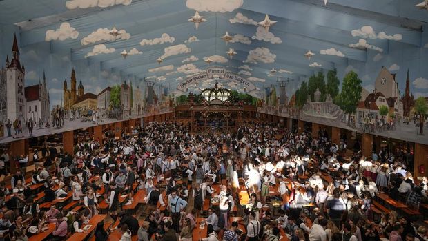 Visitors wait in the tent of the Hacker-Pschorr brewery the start of the 189th 'Oktoberfest' beer festival in Munich, Germany, Saturday, Sept. 21, 2024. (AP Photo/Matthias Schrader)