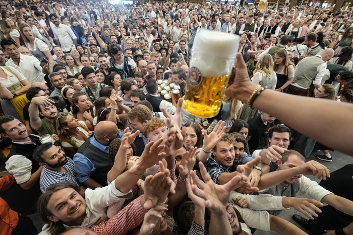 Visitors wait in the tent of the Hacker-Pschorr brewery the start of the 189th Oktoberfest beer festival in Munich, Germany, Saturday, Sept. 21, 2024. (AP Photo/Matthias Schrader)