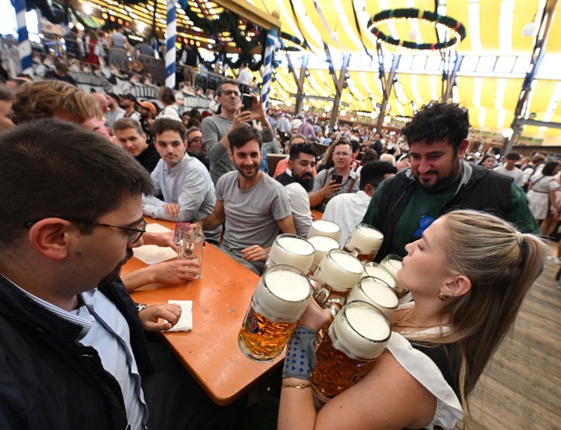 Visitors cheer and celebrate on the day of the official opening of the 189th Oktoberfest, the world's largest beer festival in Munich, Germany, September 21, 2024. REUTERS/Angelika Warmuth