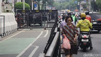 Para pejalan kaki melintas di jalan akibat penutupan jalur pedestrian di depan KPU Jakarta, Jl Salemba Raya, Jakarta, Senin (23/9/2024).  