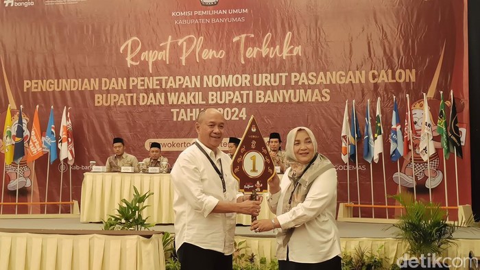 Paslon Cabup-Cawabup Sadewo Tri Lastiono-Dwi Asih Lintarti menunjukkan nomor urut dalam Pilkada Kabupaten Banyumas di Hotel Aston Purwokerto, Senin (23/9/2024) malam.