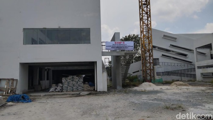 Pekerja memasang spanduk Setop Pengerjaan di Universitas Riau (Raja Adil Siregar/detikcom)