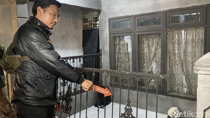 Polisi saat olah TKP rumah yang rusak akibat serangan kelompok suporter di Sukabumi.