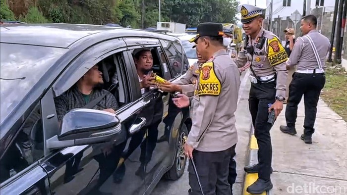 Aksi Kapolres Sukabumi, AKBP Samian bagi-bagi makanan kepada pengendara saat antrean di pintu Tol Parungkuda.