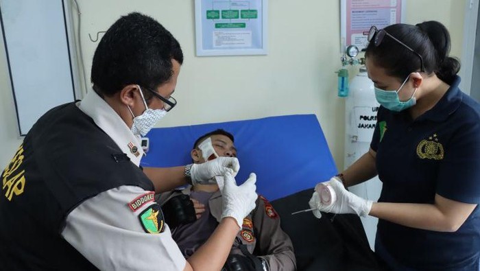Anggota Tim Patroli Perintis Presisi Polda Metro Jaya mendapat perawatan medis usai terkena siraman air keras saat berusaha membubarkan tawuran di Kembangan, Jakbar pada Sabtu (21/9). (ANTARA/HO-Polres Jakbar)