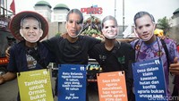Beberapa orang tampak memakai topeng yang salah satunya bergambar Jokowi.