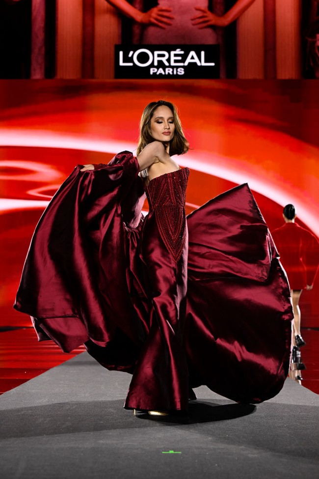 Untuk momen istimewa tersebut, tubuhnya dibungkus jumpsuit merah wine. Busana tersebut hadir dengan bodice berbentuk korset yang bertaburan detail kristal berkilauan nan glamor. (Foto: Kristy Sparow/Getty Images for LOréal Paris)