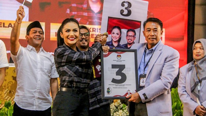 Ketua KPU Kota Batu Heru Joko Purwanto (kanan) menyerahkan plakat nomor urut kepada calon Wali Kota Batu nomor urut tiga Krisdayanti (kiri) saat Pengundian dan Penetapan Nomor Urut Pasangan Calon Wali Kota dan Wakil Wali Kota Batu di Kota Batu, Jawa Timur, Senin (23/9/2024). KPU Kota Batu menetapkan pasangan calon Wali Kota dan Wakil Wali Kota Nurochman - Heli Suyanto dengan nomor urut satu, sementara pasangan Firhando Gumelar - Rudi dengan nomor dua, dan pasangan Krisdayanti - Kresna Dewanata Phrosakh nomor urut tiga. ANTARA FOTO/Muhammad Mada/aww.