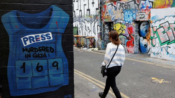 A man walks past a mural in support of Palestinians featuring a press flak jacket with a number of journalists killed in Gaza, amid the ongoing Israel-Hamas conflict, in Dublin, Ireland September 22, 2024. REUTERS/Clodagh Kilcoyne