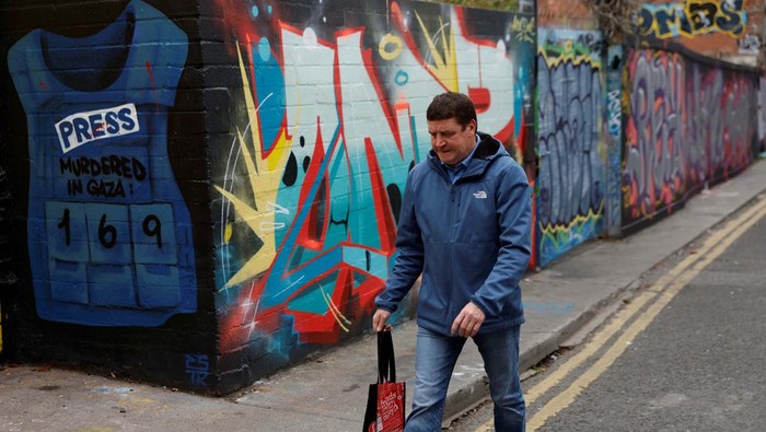 Mural Dukung Palestina Mejeng di Dublin A man walks past a mural in support of Palestinians featuring a press flak jacket with a number of journalists killed in Gaza, amid the ongoing Israel-Hamas conflict, in Dublin, Ireland September 22, 2024. REUTERS/Clodagh Kilcoyne