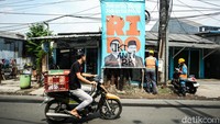 Pengendara melintas di depan baliho Ridwan Kamil-Suswono di kawasan Pulogebang, Jakarta Timur, Selasa (24/9/2024).