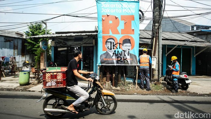 Pengendara melintas di Kawasan Pulogebang, Jakarta Timur, Selasa (24/9/2024). Sejumlah baliho milik pasangan Cagub Cawagub no urut 1 Ridwan Kamil-Suswono nampak dirusak.