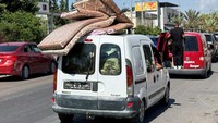 Warga membawa barang-barang yang diperlukan untuk mengungsi. 