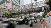 Pekerja menyelesaikan pembangunan jembatan penyeberangan orang (JPO) di Jalan K.H Mas Mansyur, Jakarta.