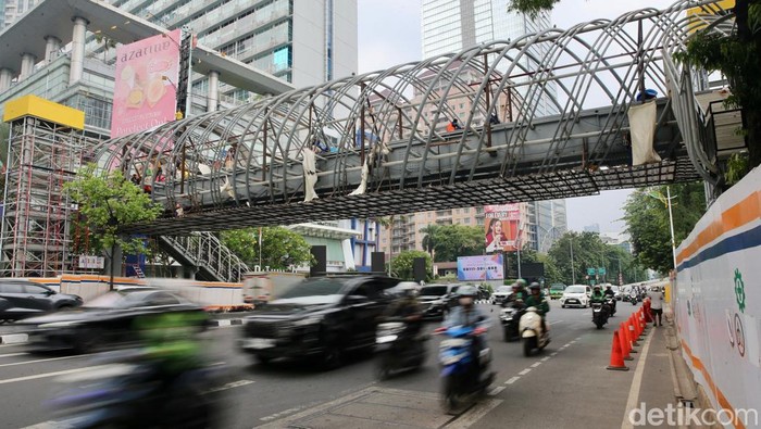 Pekerja menyelesaikan pembangunan jembatan penyeberangan orang (JPO) di Jalan K.H Mas Mansyur, Jakarta, Selasa (24/9/2024).
