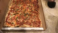 Bukan lagi sebesar kepala manusia, porsi pizza ‘raksasa’ ini panjangnya lebih dari ukuran orang dewasa. Foto: Pool/Site
