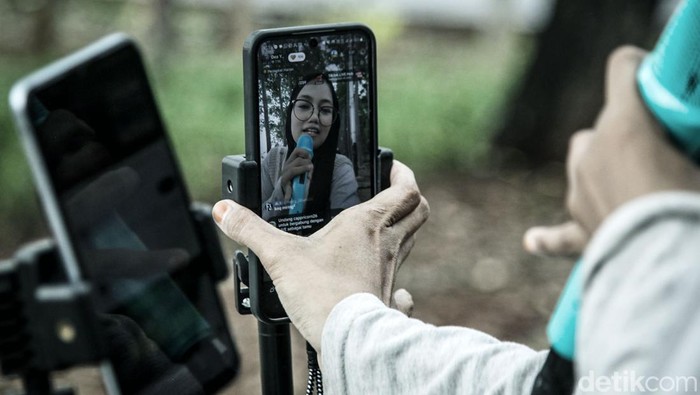 Konten kreator live streaming di ruang terbuka jadi fenomena baru di tengah sulitnya lapangan pekerjaan. Mereka memanfaatkan TikTok untuk meraup penghasilan lewat bernyanyi. Seperti yang terjadi di kawasan BKT Duren Sawit ini.