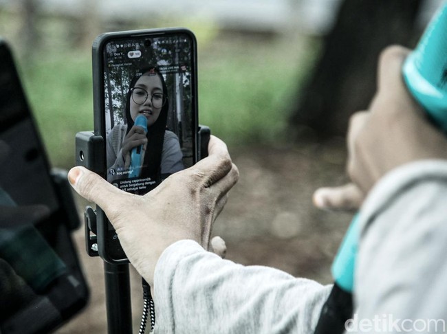 Konten kreator live streaming di ruang terbuka jadi fenomena baru di tengah sulitnya lapangan pekerjaan. Mereka memanfaatkan TikTok untuk meraup penghasilan lewat bernyanyi. Seperti yang terjadi di kawasan BKT Duren Sawit ini.