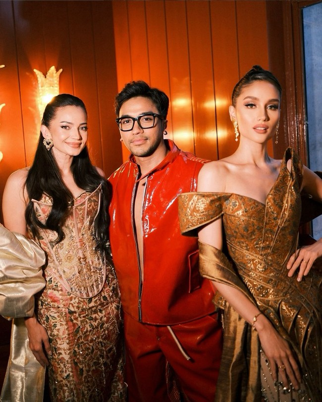 Cinta Laura mengenakan gaun asimetris dengan motif Batik Solo yang dominan palet cokelat. Gaun berpotongan off-shoulder ini juga dilengkapi selendang bernuansa emas yang menambah kesan glamor. Foto: (Instagram/@enzystoria @bubahalfian)