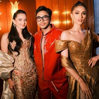 Cinta Laura mengenakan gaun asimetris dengan motif Batik Solo yang dominan palet cokelat. Gaun berpotongan off-shoulder ini juga dilengkapi selendang bernuansa emas yang menambah kesan glamor. Foto: (Instagram/@enzystoria @bubahalfian)