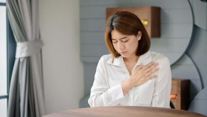 An Asian woman clutched her chest due to suffering from a sudden heart attack.
