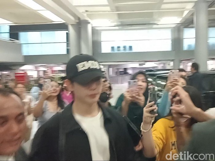 Jung Hae In (topi hitam) dan Kim Yoon Ji alias Jung So Min mendarat di Bandara Internasional Ngurah Rai, Selasa (24/9/2024), sekira pukul 23.10 Wita. (Aryo Mahendro/detikBali).