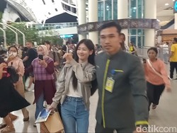 Jung So Min tampak memberikan love sign dengan penggemarnya saat tiba di Bandara Ngurah Rai.