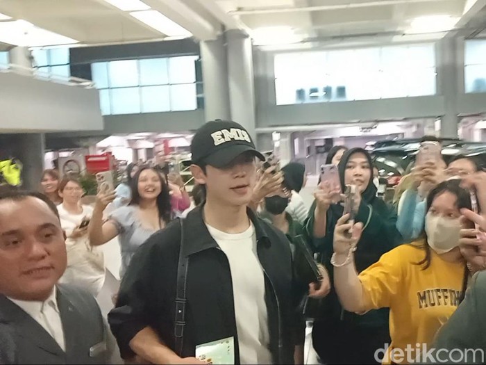 Jung Hae In (topi hitam) dan Kim Yoon Ji alias Jung So Min mendarat di Bandara Internasional Ngurah Rai, Selasa (24/9/2024), sekira pukul 23.10 Wita. (Aryo Mahendro/detikBali).