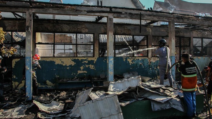 Petugas pemadam kebakaran melakukan pendinginan pada puing bangunan Gereja Maranatha yang hangus terbakar di Palangka Raya, Kalimantan Tengah, Selasa (24/9/2024). Kebakaran yang terjadi pada bangunan gereja tersebut merembet ke SMP Kristen Palangka Raya sehingga menghanguskan empat ruangan kelas, sementara penyebab kebakaran masih dalam penyelidikan kepolisian. ANTARA FOTO/Auliya Rahman/aww.