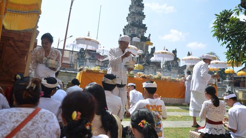 Pemuka agama Hindu memercikkan air suci saat persembahyangan Hari Raya Galungan di Pura Jagatnatha, Denpasar, Bali, Rabu (25/9/2024). Hari Raya Galungan dirayakan umat Hindu sebagai hari kemenangan kebenaran (Dharma) atas kejahatan (Adharma) dengan melakukan persembahyangan di tiap-tiap pura yang ada di Bali. ANTARA FOTO/Fikri Yusuf/rwa.
